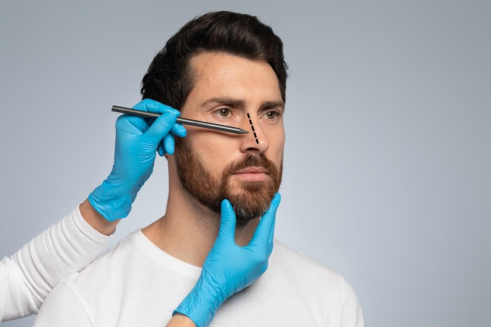 Médico desenhando marcas no nariz do homem para operação de cirurgia