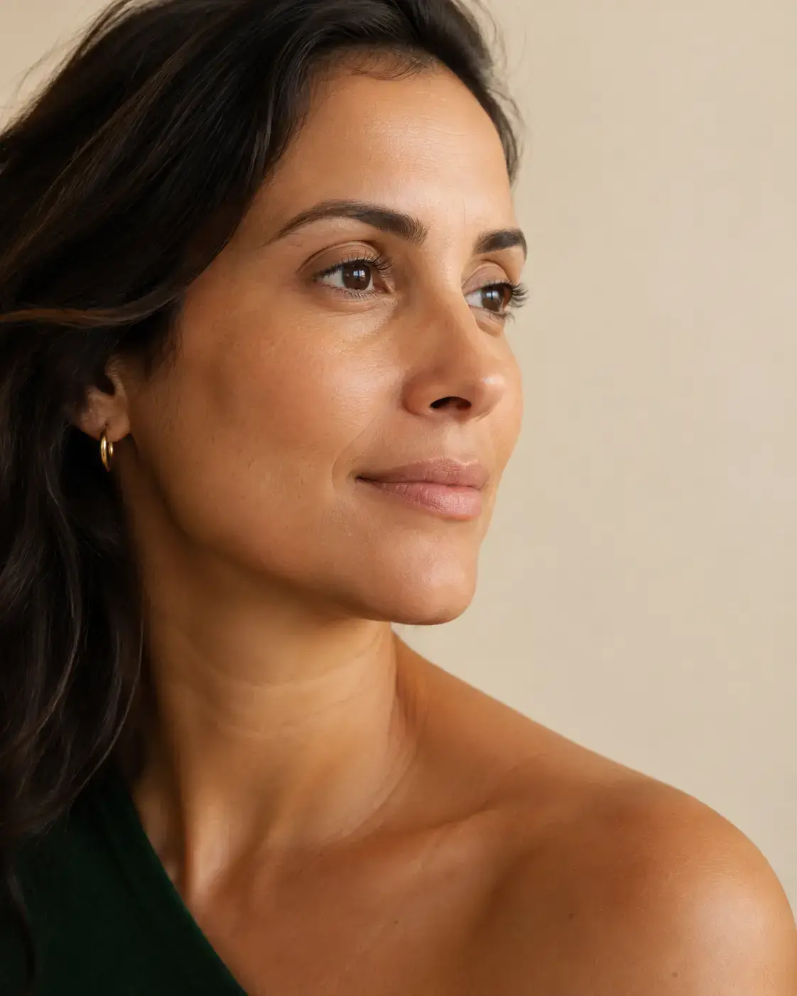 Retrato de perfil de mulher adulta com pele natural, em luz quente.