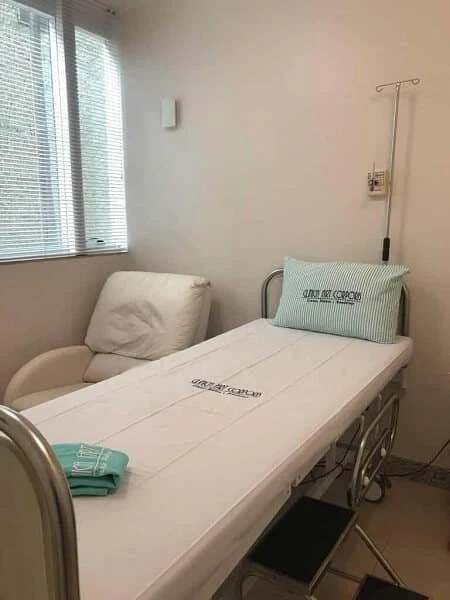 Leito do Hospital Dia da Clínica Art Corporis, com poltrona de acompanhante e suporte de soro.