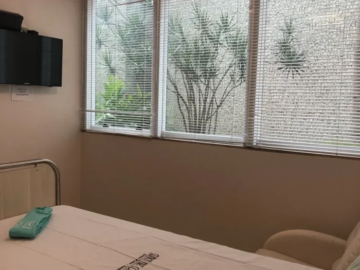 Quarto de internação de curta permanência com televisão e janela, na Clínica Art Corporis, em Brasília.