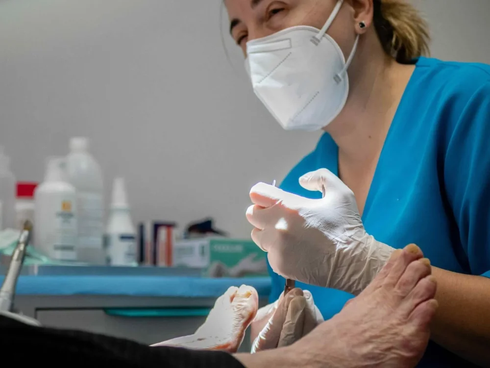 Profissional de saúde preparando material para procedimento em consultório.