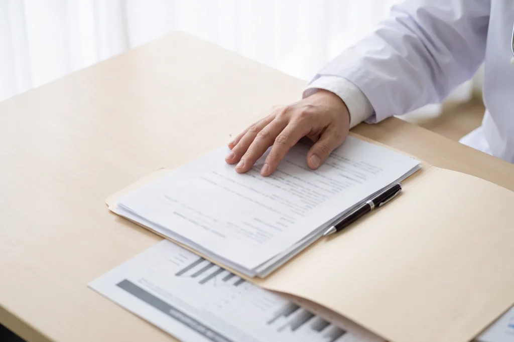 Documentos e exames sobre a mesa do consultório.