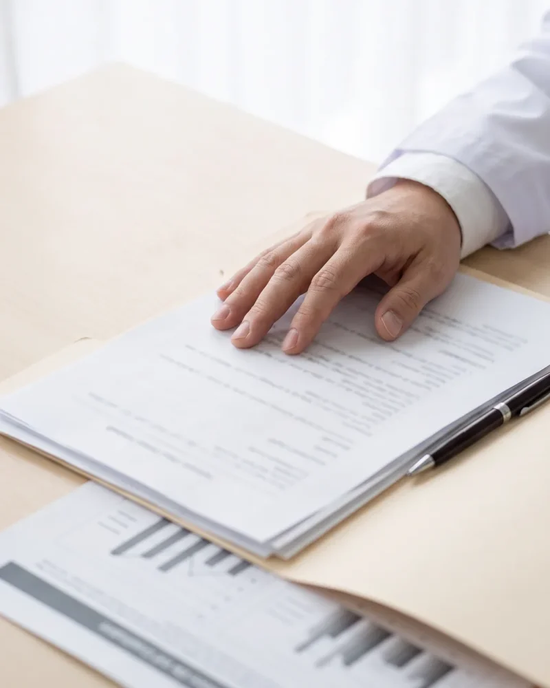Documentos e exames sobre a mesa do consultório.